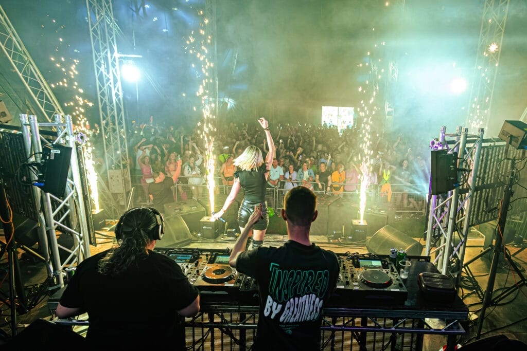 DJs and a lady dancing with the crowd watching at Meridian Showground