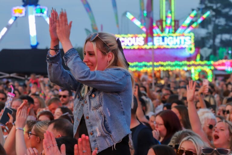Close up of a woman on someone's shoulders in the audience at Meridian Showground